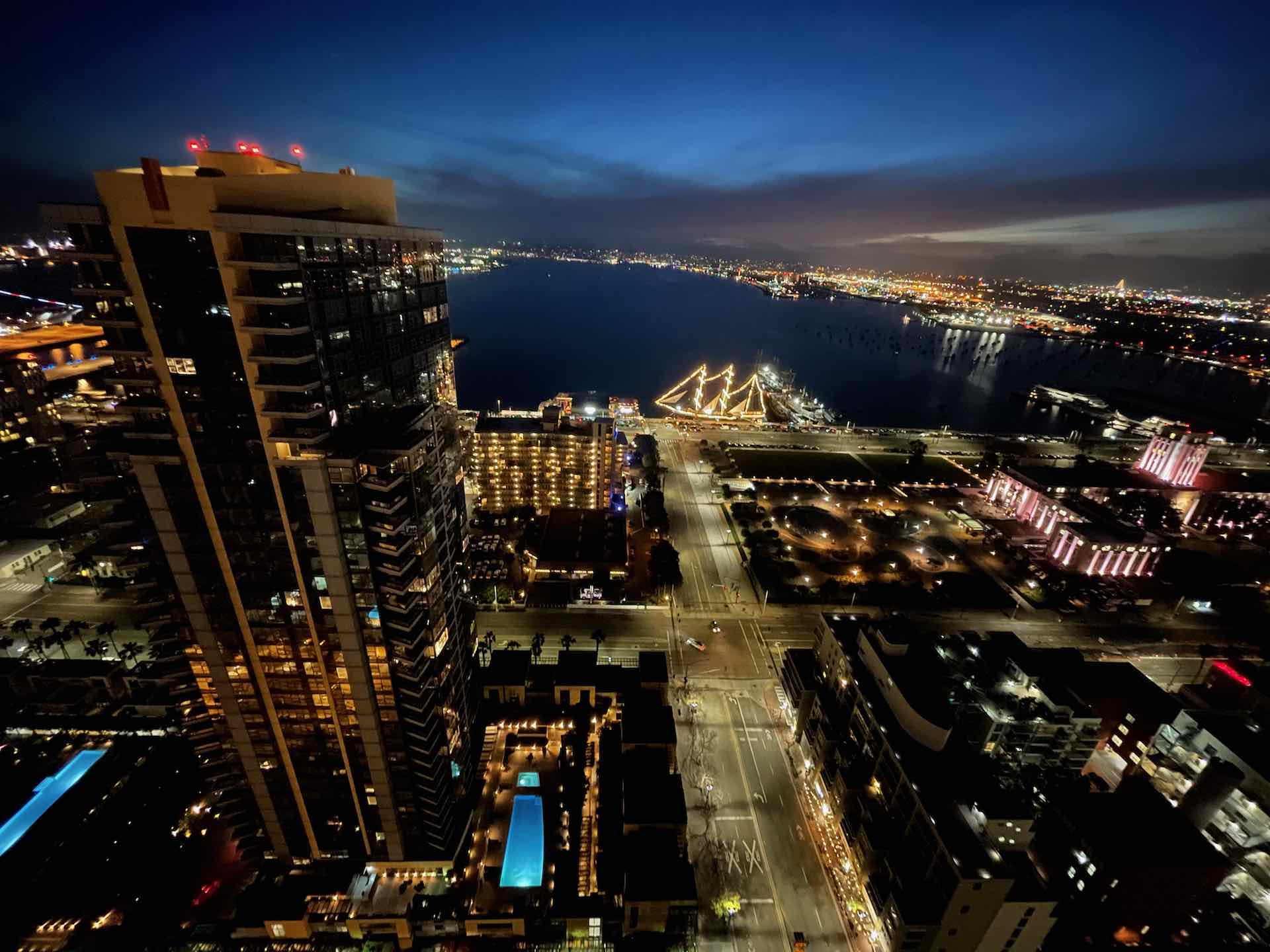 aerial view at night of the San Diego bay and surrounding buildings